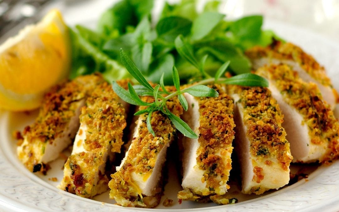 Nut-crusted chicken with lemon wedge