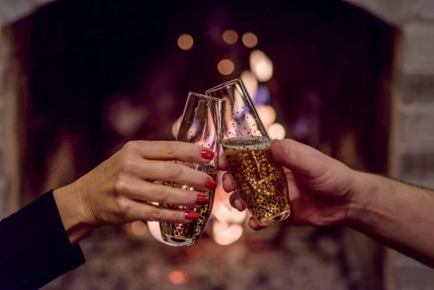 Couple toasts to the new year with a glass of champagne.